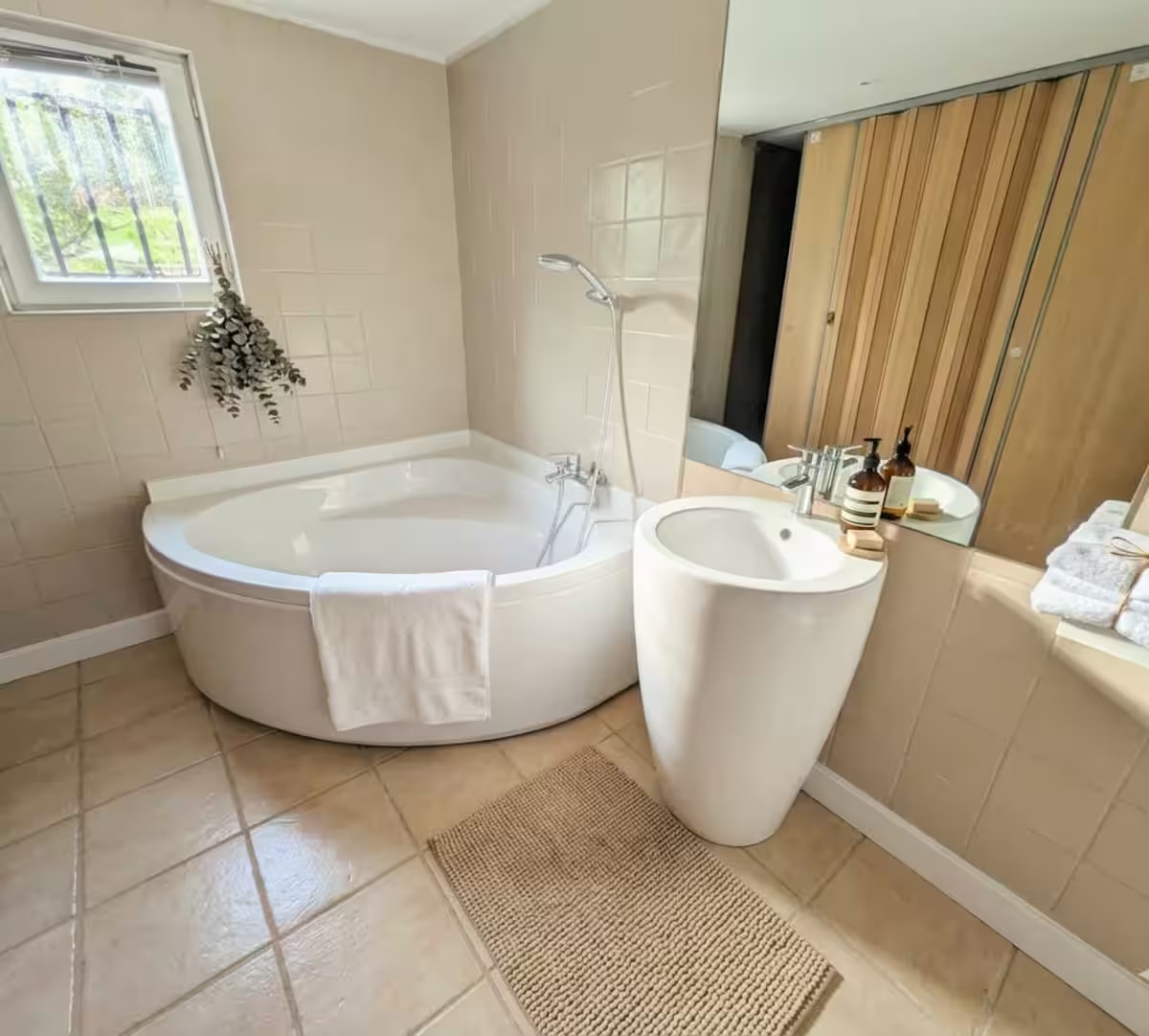 Bathroom with corner bath and pedestal basin